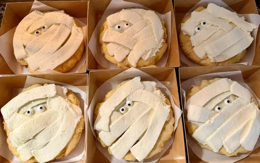 Mini cookie cakes iced with buttercream strips and candy eyes to look like mummies